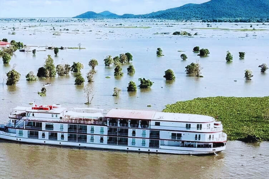 Luxury white Mekong River Cruise ship sailing through flooded forest views Vietnam